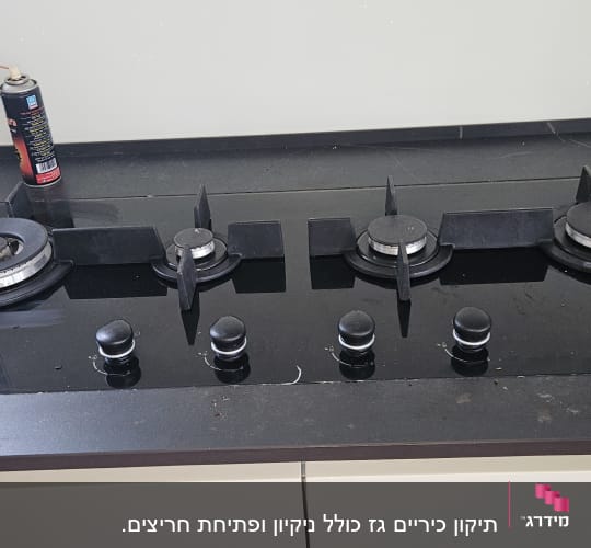 כיריים גז שחורות עם חמישה מבערים וכפתורי שליטה